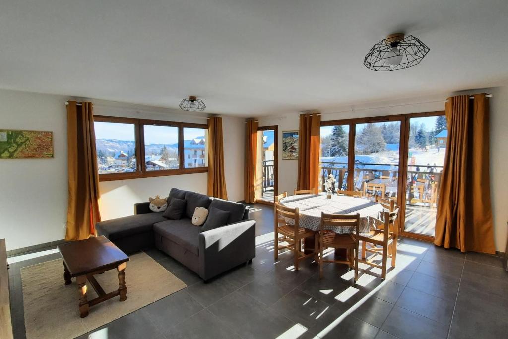 a living room with a couch and a table at Spacieux appartement au pied des pistes in La Féclaz