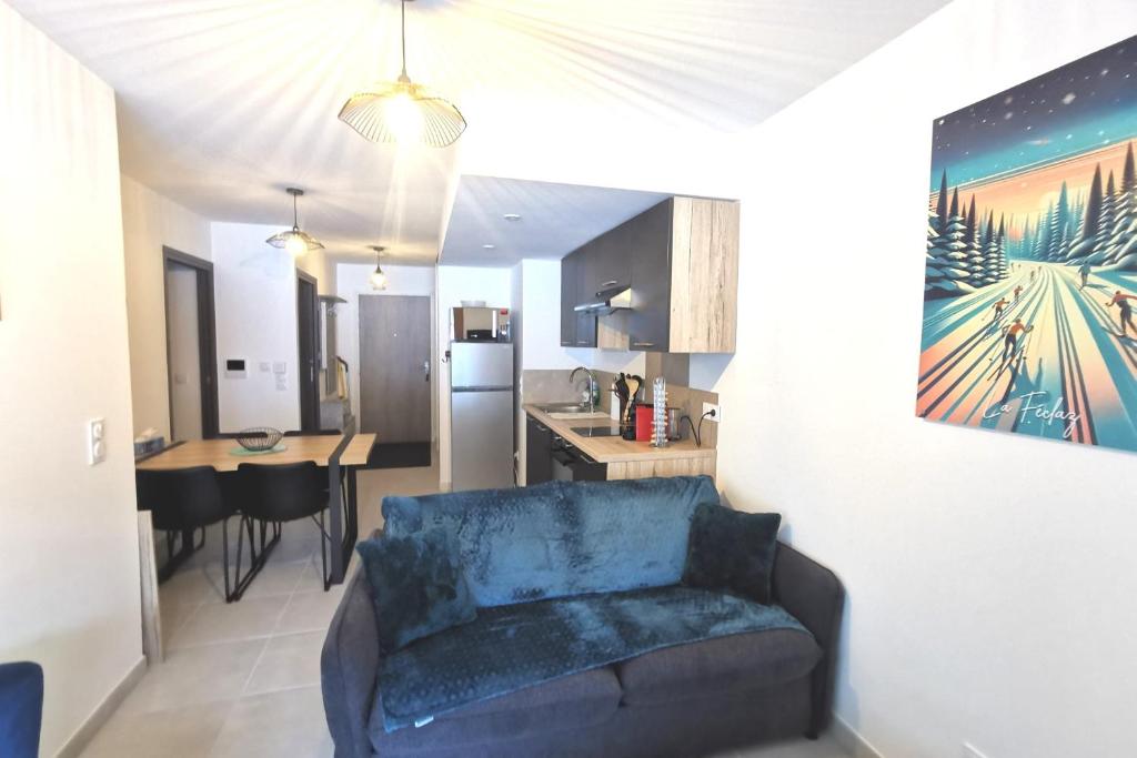 ein Wohnzimmer mit einem Sofa und einer Küche in der Unterkunft Superbe appartement au pied des pistes in La Feclaz