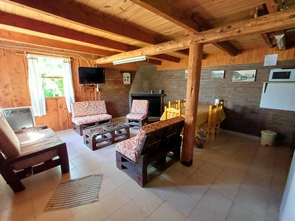 un soggiorno con sedie e un camino in una casa di Posada El Maiten a Trevelin