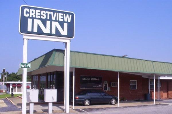 a car parked in front of a building with a sign at Crestview Inn in Crestview