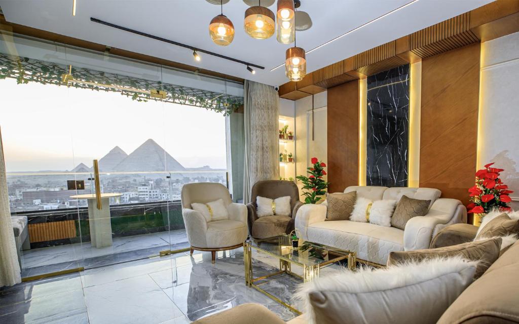 uma sala de estar com sofás e vista para as pirâmides em Piccolo Mondo Boutique Hotel no Cairo