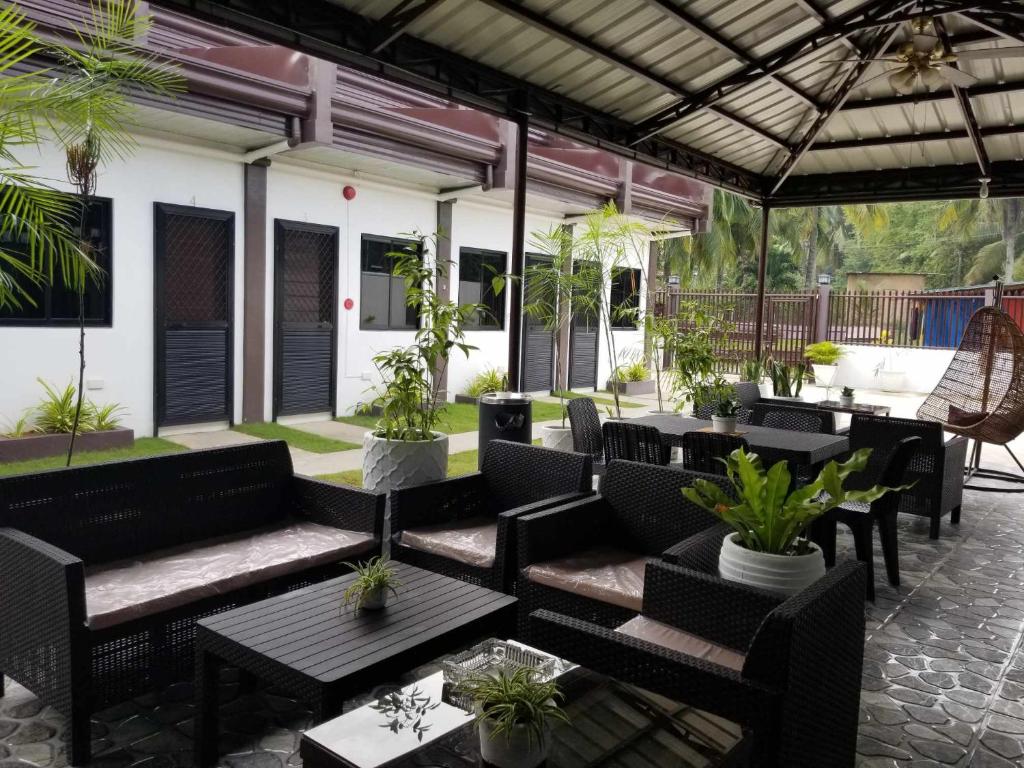 an outdoor patio with tables and chairs and plants at JSS PENSION HOUSE 