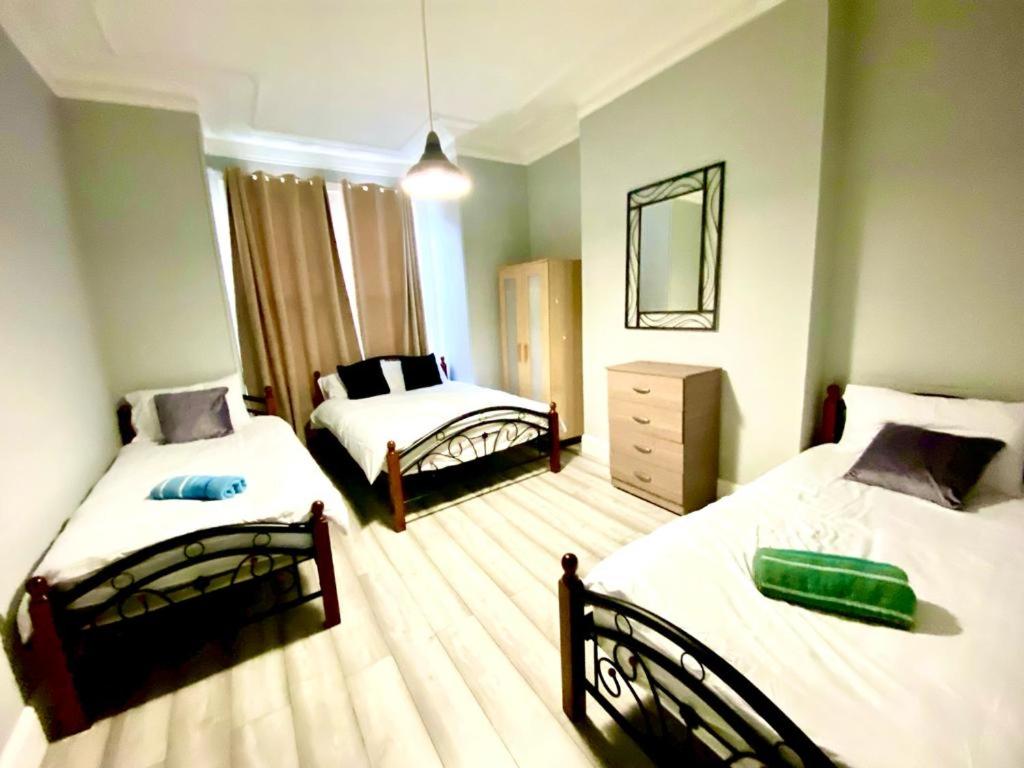 um quarto com 2 camas e um espelho em One Bedroom Ground Floor Flat In Central London em Londres