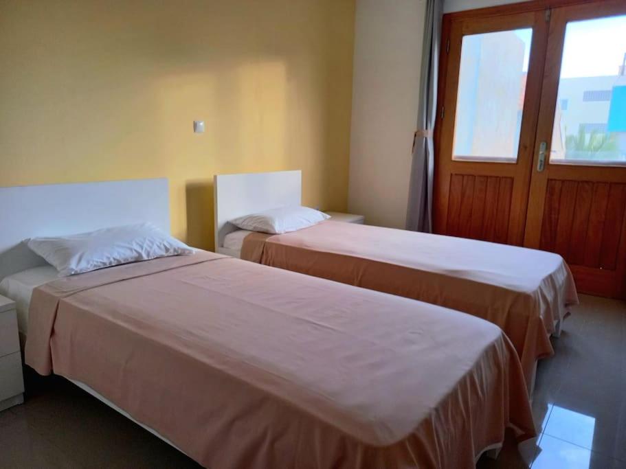 2 camas en una habitación de hotel con ventana en Apartamento em Santa Maria- Espaçoso&Confortável en Santa María