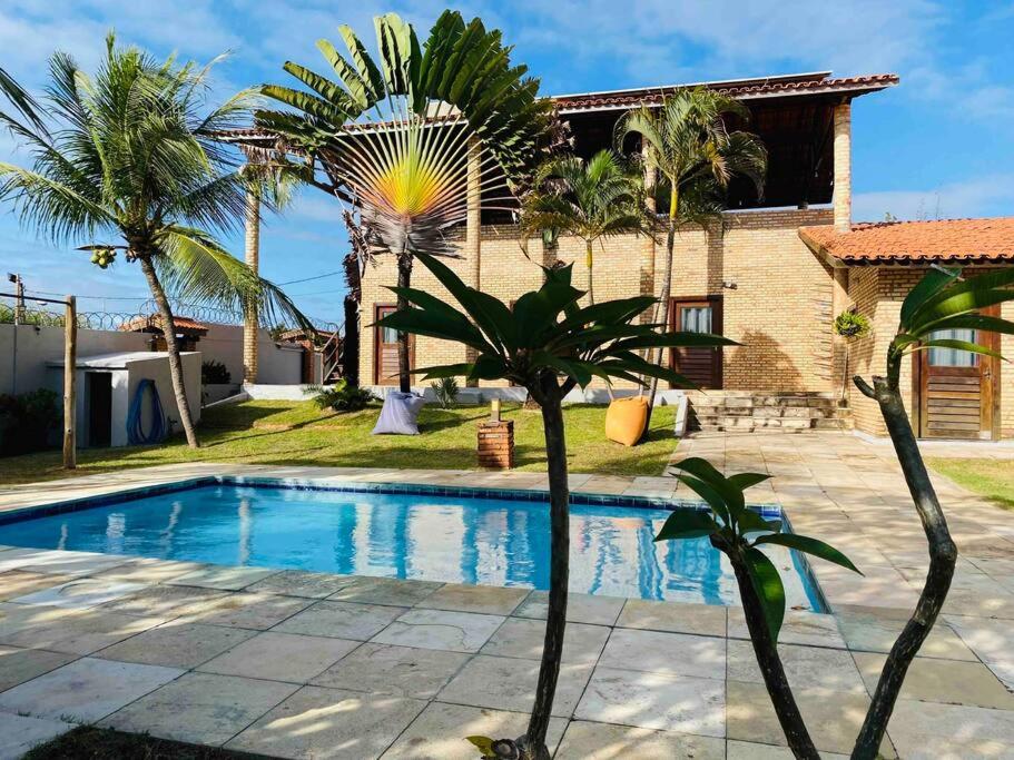 eine Villa mit einem Pool vor einem Haus in der Unterkunft Casa do Ric in Caucaia