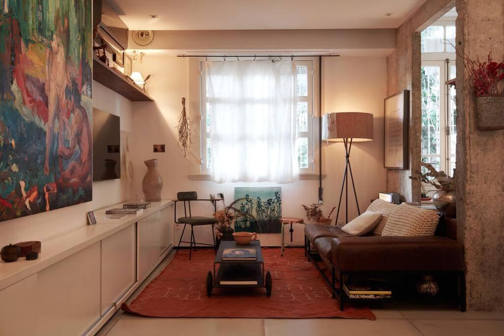 a living room with a couch and a table at Apartamento único no coração do Jardim Botânico in Rio de Janeiro