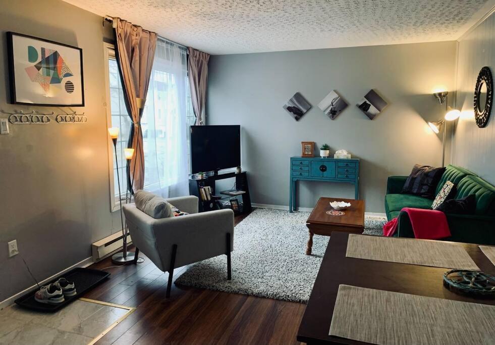 un soggiorno con divano e tavolo di Cozy 2-BDRM, Mid Floor, Backyard a Halifax