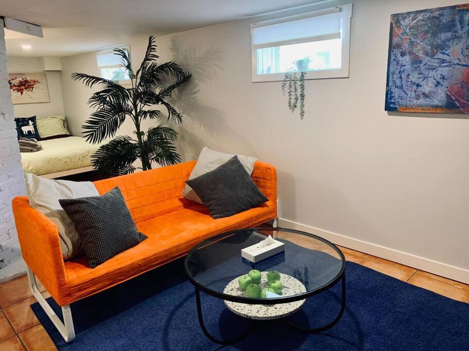 a living room with an orange couch and a table at Charming North End Studio #2 in Halifax