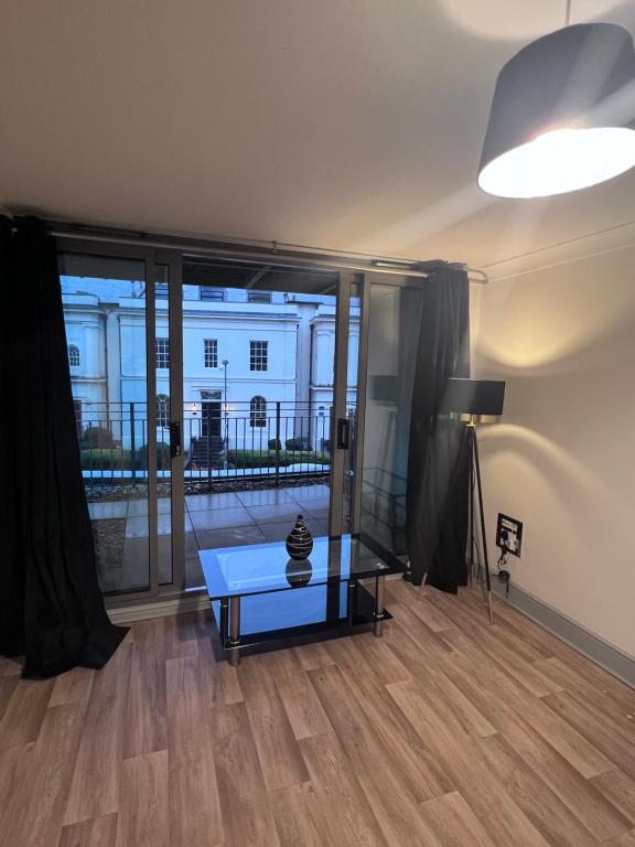 a living room with a table and a large window at Broad street - Balcony 1 bedroom apartment in Birmingham