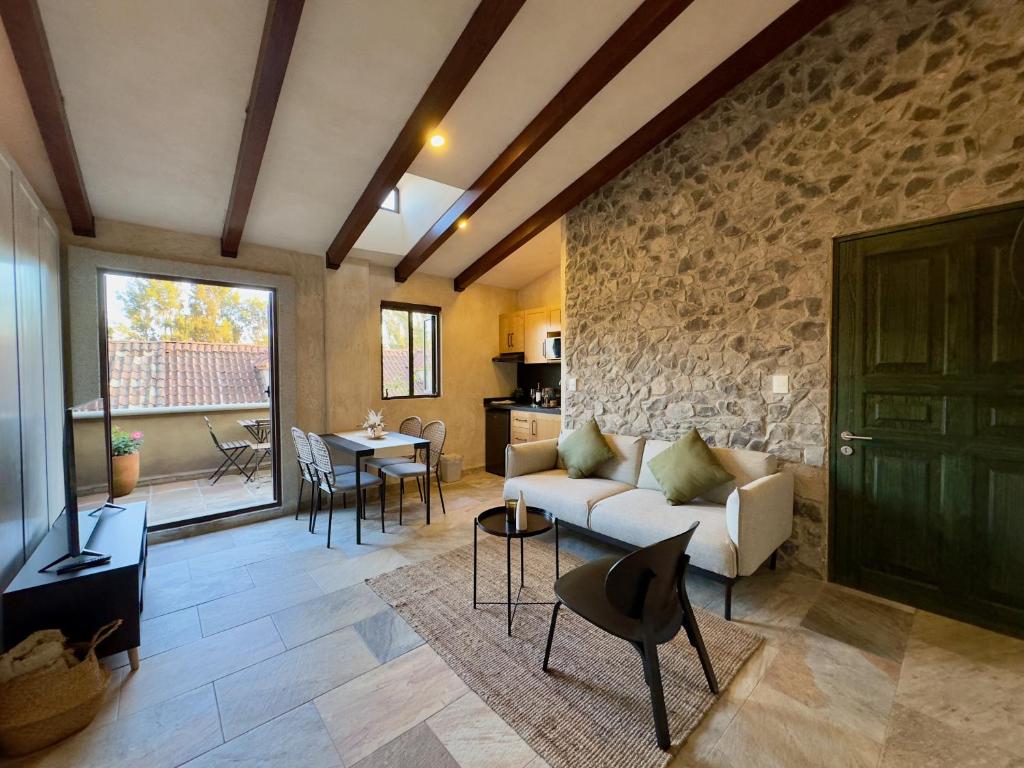 a living room with a couch and a stone wall at Loft Arena en ValQuirico in Santeagueda