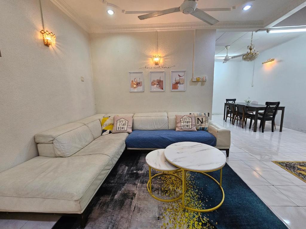 sala de estar con sofá y mesa en Ruhani Homestay 3 KB - 4 Bedroom Fully Airconditioned with WIFI & Netflix, en Kota Bharu