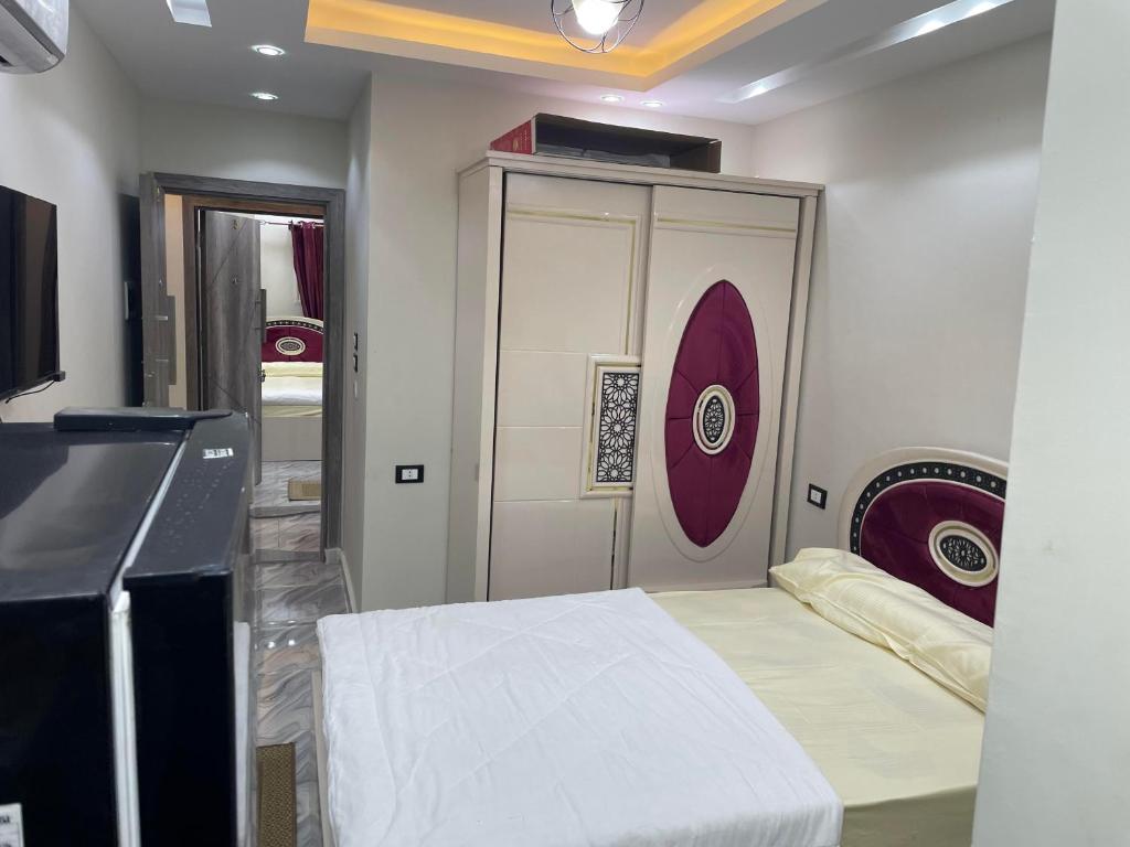 Zimmer mit einem Bett und einem Schrank mit einer Tür in der Unterkunft ستديو فندقي in Madinat as-Sadis min Uktubar