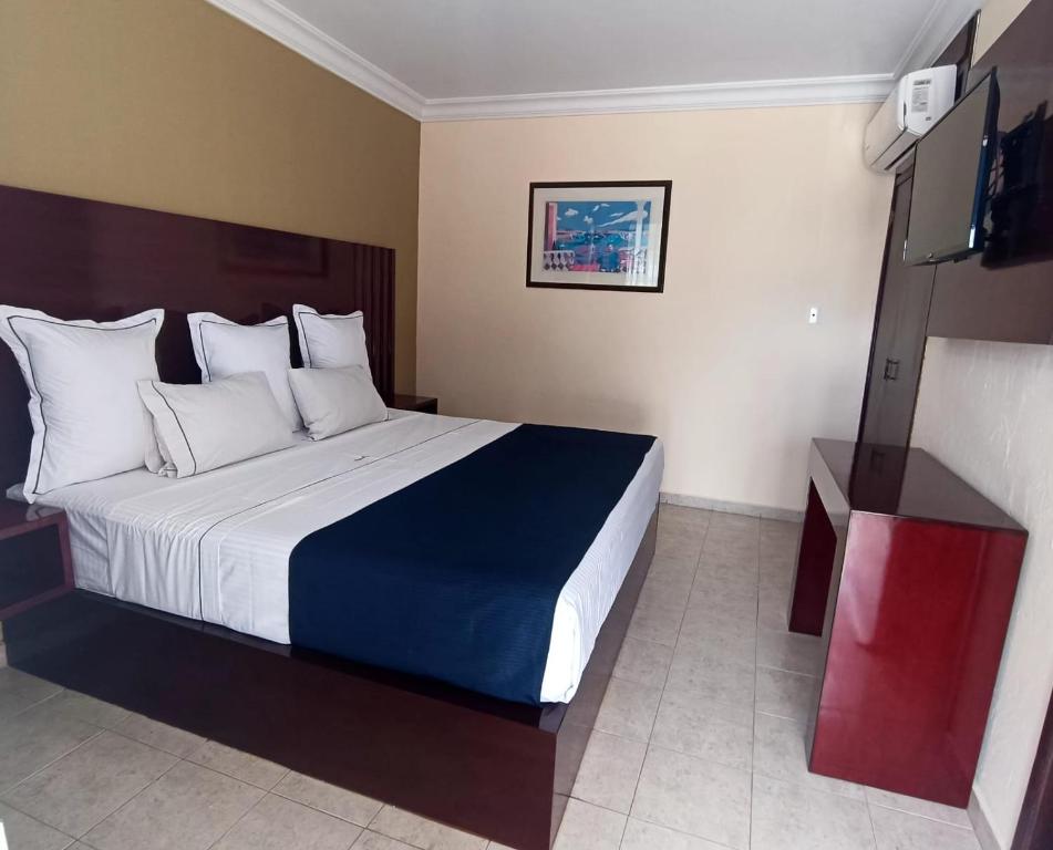 um quarto de hotel com uma cama grande num quarto em Hotel Confort Plaza em Culiacán