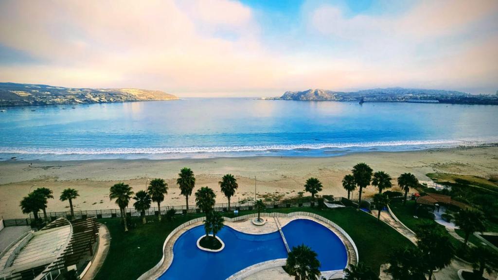 uma vista para a praia e para o oceano a partir de um resort em Condominio costazul La Herradura em Coquimbo