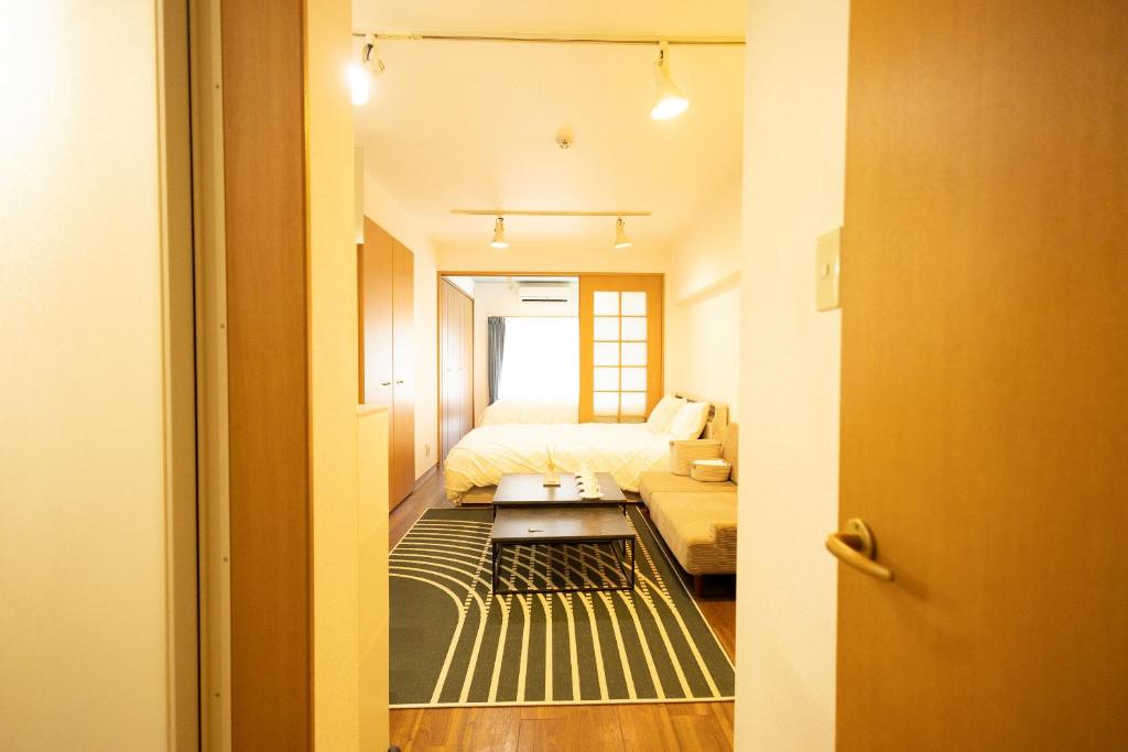 Habitación pequeña con cama y sofá en 渋谷駅から6分/FREEWiFi/貸切マンション一室/33㎡/可做饭/中国語&韓国語&英語, en Tokio