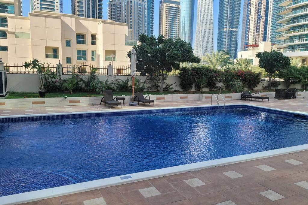 a large swimming pool in a city with tall buildings at Full Marina View 2BR Luxury Apartment in Dubai