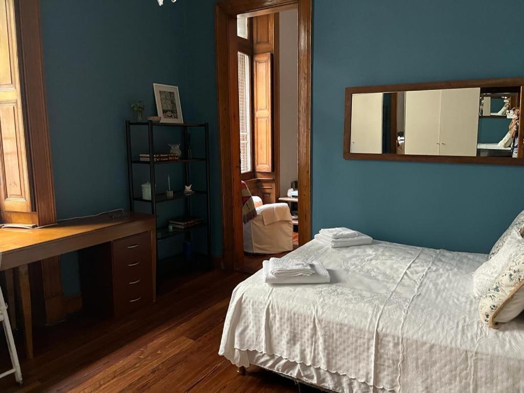 Dormitorio azul con cama y espejo en GABY'S HOME en Buenos Aires