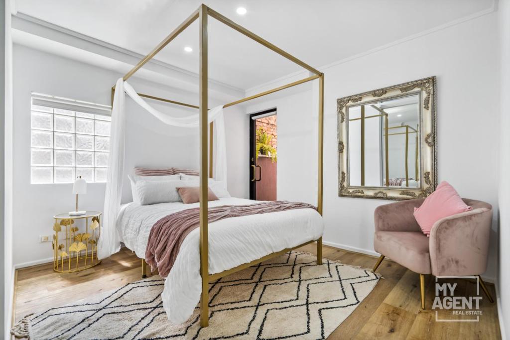 um quarto com uma cama de dossel e uma cadeira em Central City Chic - sleeps 6, free parking em Melbourne