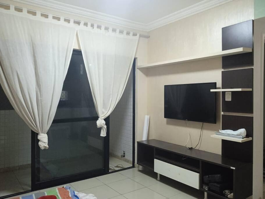 salon z telewizorem i zasłoną w obiekcie Apartamento em Salvador w mieście Salvador