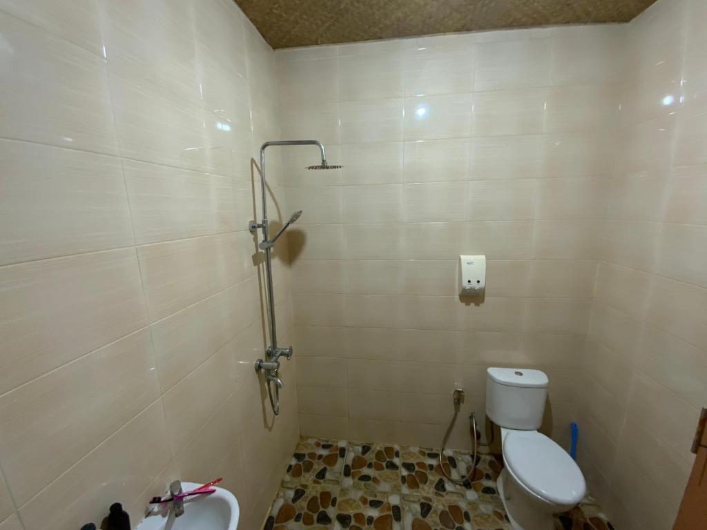 La salle de bains est pourvue de toilettes et d'une douche. dans l'établissement Balinese Villa Syariah, à Sekupang