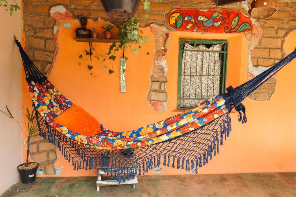 una hamaca colgada en la pared de una habitación en Oásis - charme e aconchego, perto de tudo!, en Alto Paraíso de Goiás