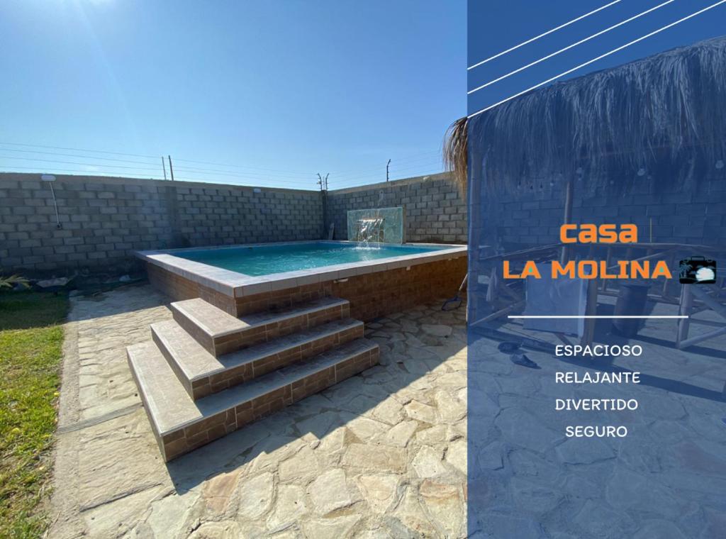 a swimming pool with stairs next to a building at Casa Colan La Molina in Paita
