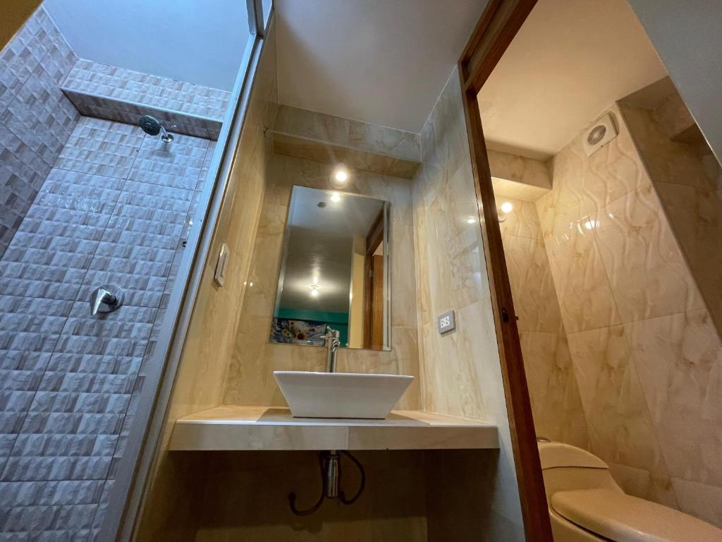 een badkamer met een wastafel en een douche bij casa marfil tourist house in Cuzco