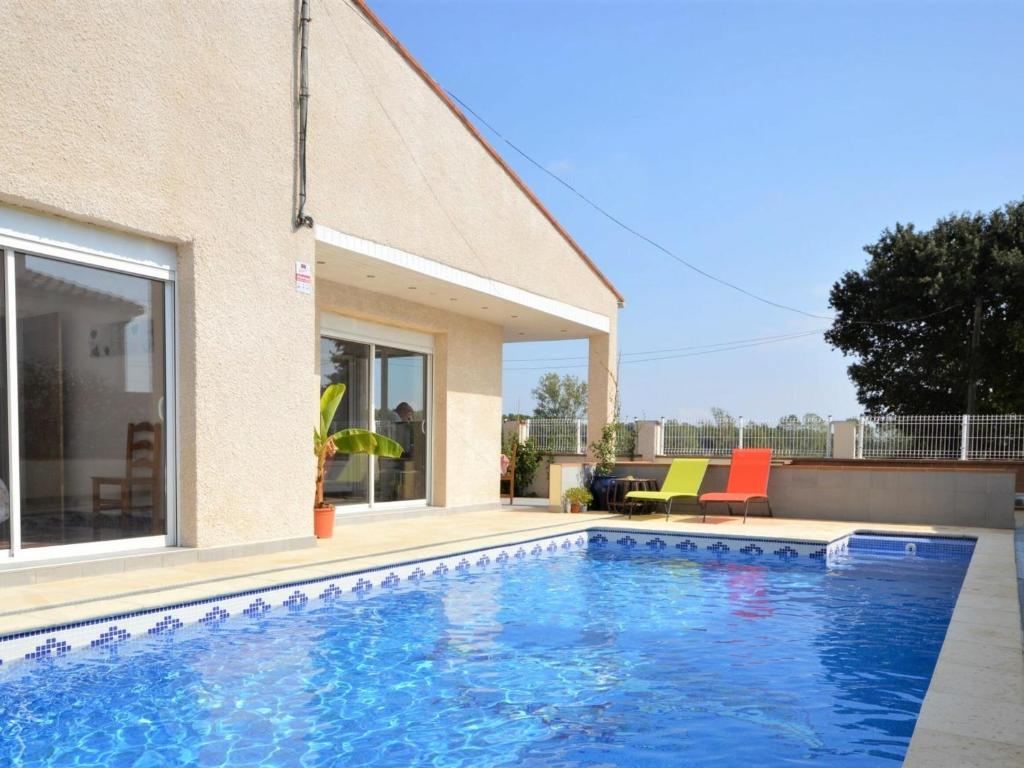 a swimming pool in front of a house at Casa Sant Miquel de Fluvià, 4 dormitorios, 10 personas - ES-89-91 in San Miguel de Fluviá