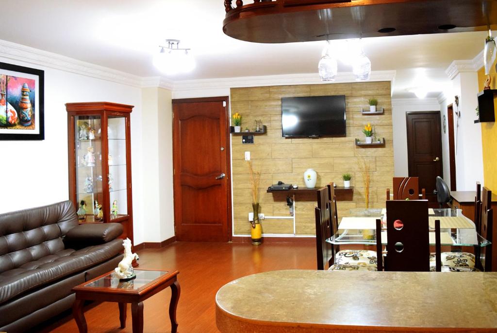 a living room with a couch and a tv on a wall at Hermoso apartamento en el centro de Ipiales in Ipiales