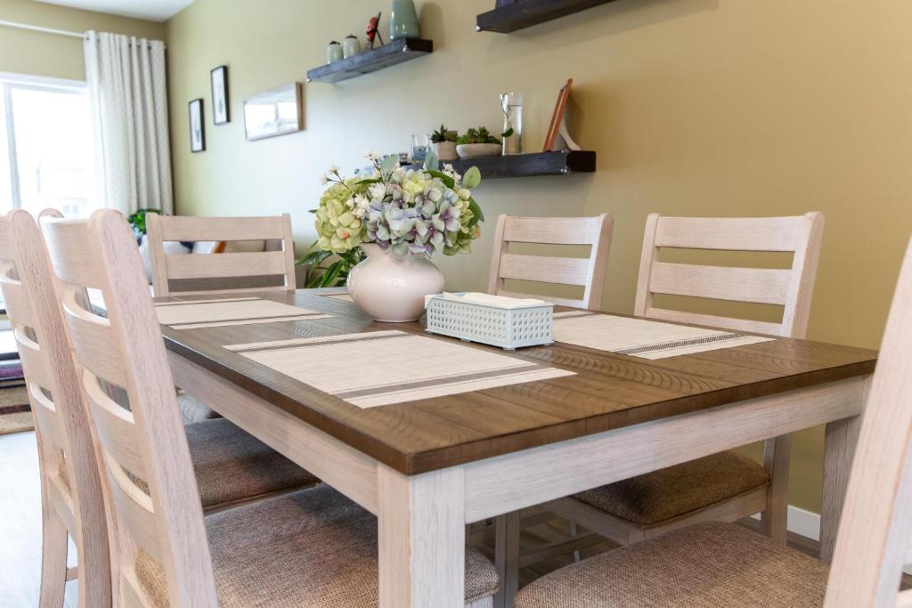 stół jadalny z krzesłami i wazon z kwiatami w obiekcie Single detached house with 3 BRM w mieście Edmonton