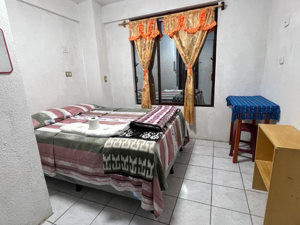 um quarto com uma cama e uma janela com cortinas em POSADA DOÑA ELENA LA COMADRONA em San Juan La Laguna