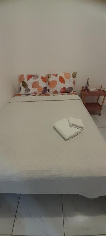 a white bed with two pillows on top of it at Casa em João Pessoa Paraíba in João Pessoa