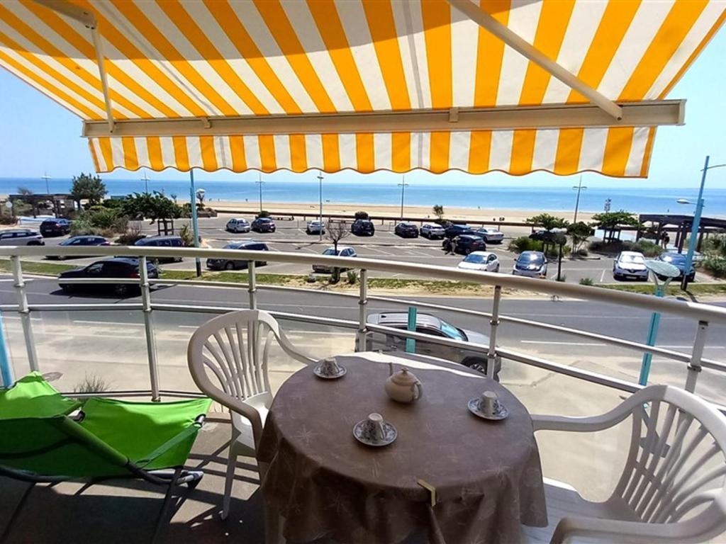 d'une table et de chaises sur un balcon avec vue sur le parking. dans l'établissement Bel Appartement Face Mer - 1 Chambre - Classé 2* - Parking - 5 personnes - FR-1-323-299, à Saint-Jean-de-Monts