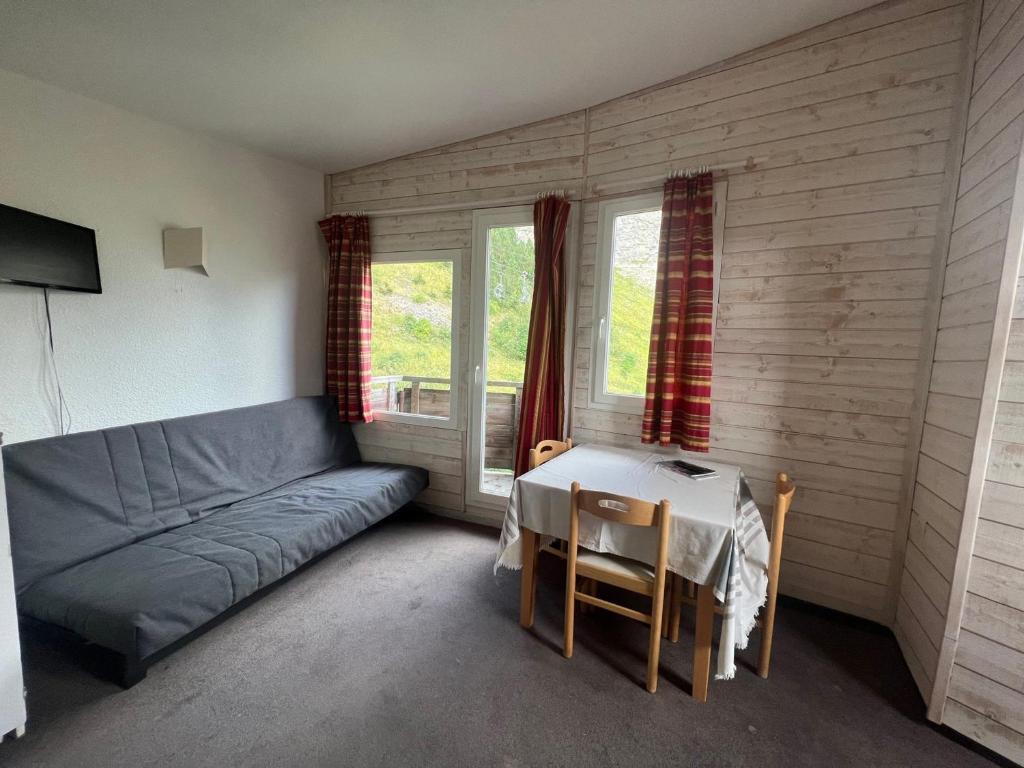 Cette chambre comprend un canapé, une table et des fenêtres. dans l'établissement Studio 3 pers, Wi-Fi, Centre Avoriaz - FR-1-314-281, à Morzine