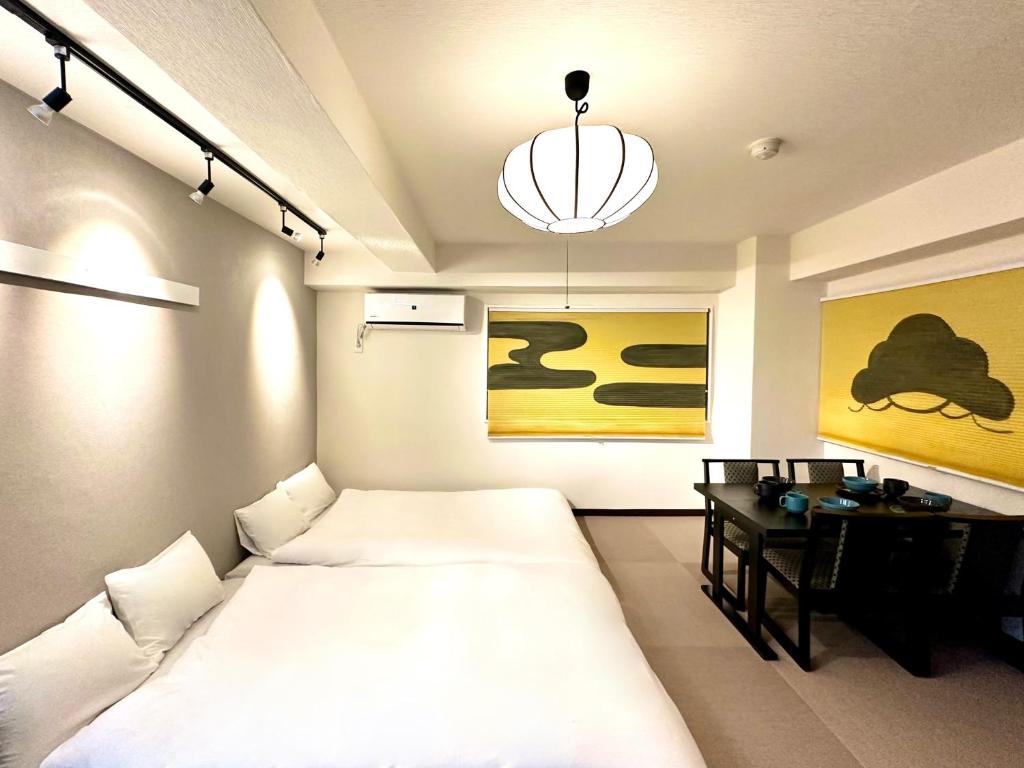 a bedroom with a bed and a desk and a chandelier at LOVE UENO 2-4人アクセス抜群 山手線3分 上野浅草銀座近い 御徒町駅3分 アメ横3分 上野駅10分 上野広小路駅3分 湯島駅2分 和風畳寝室 in Tokyo