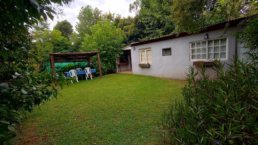 un patio con sillas y un cenador junto a una casa en quinta el ensueño en General Rodríguez