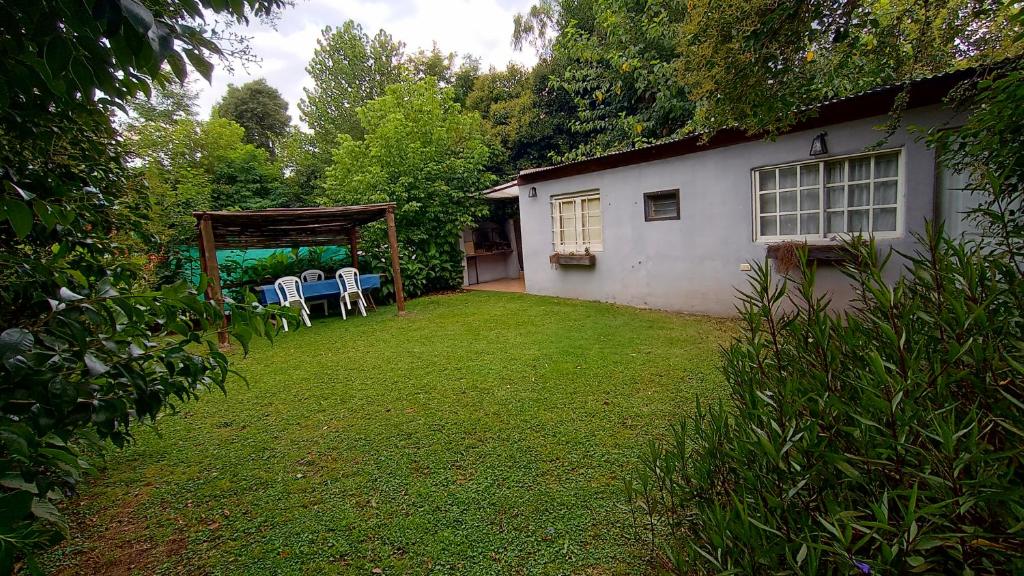 a yard with chairs and a gazebo next to a house at quinta el ensueño in General Rodríguez