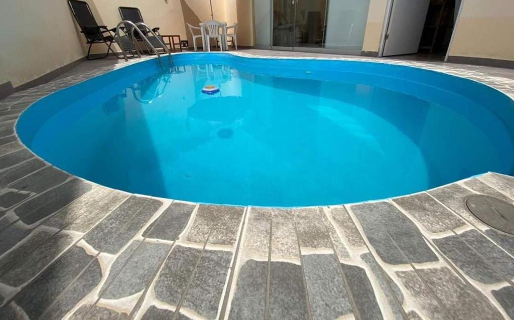 een groot blauw zwembad in een gebouw bij CASA DE PLAYA CON PISCINA PUNTA NEGRA in Punta Hermosa