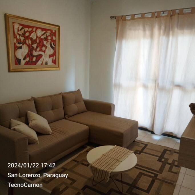 ein Wohnzimmer mit einem Sofa und einem Tisch in der Unterkunft Departamento en San Lorenzo in San Lorenzo