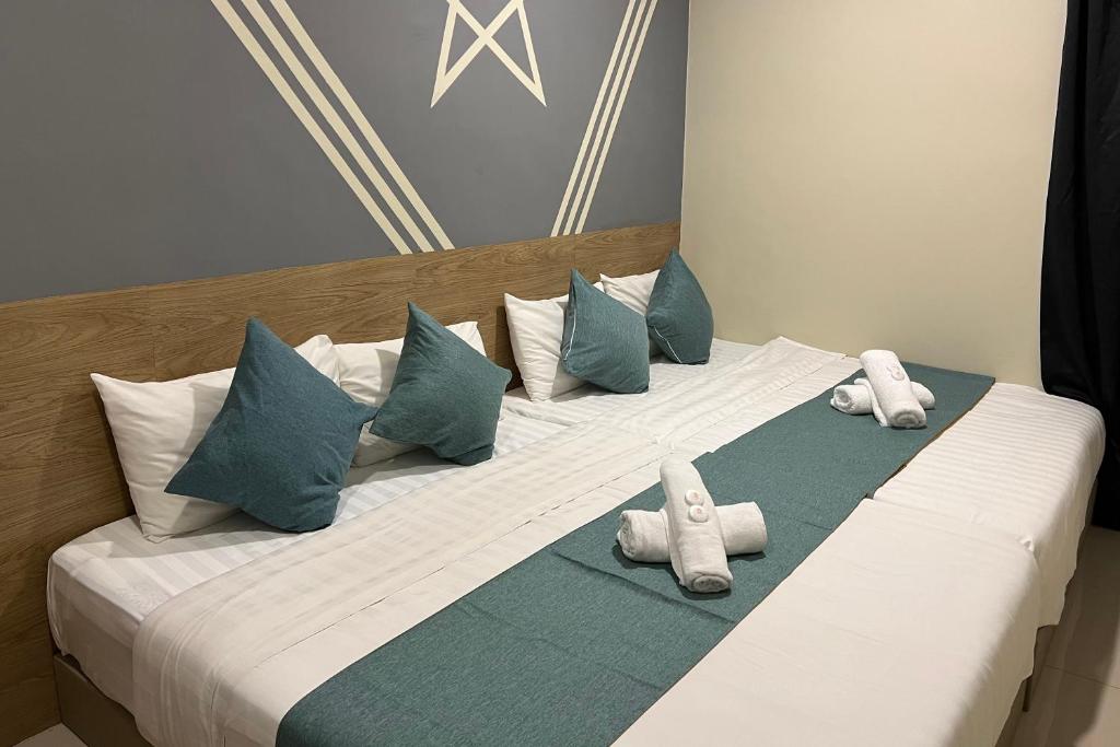 een groot bed met kussens en handdoeken erop bij KUANTAN BESERAH BUDGET HOTEL in Kuantan