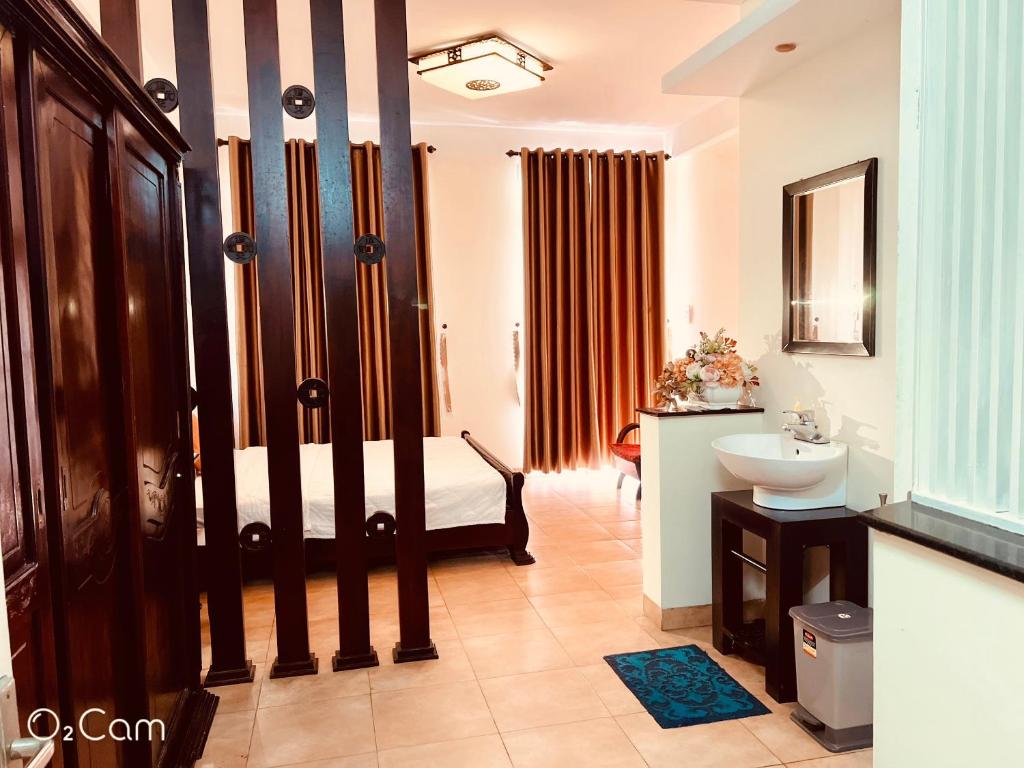 a bathroom with a bed and a sink in it at Khang Homestay in Da Nang