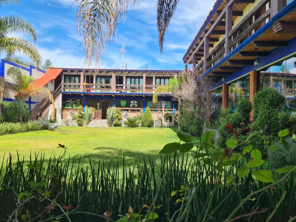 an exterior view of a building with a yard at La Finca del Abuelo Teotihuacan in San Juan Teotihuacán