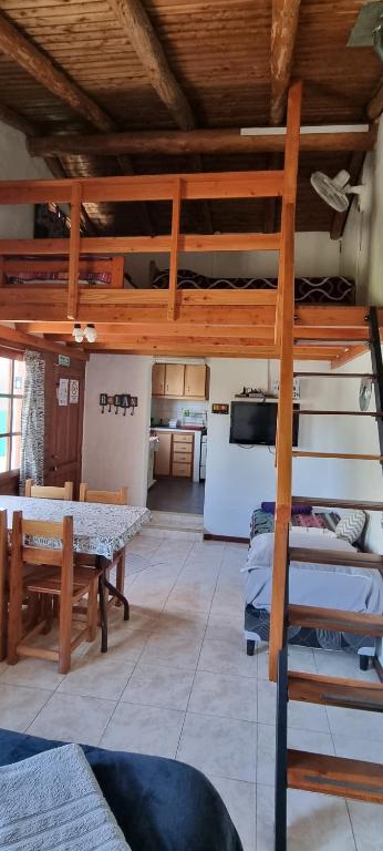 Habitación con cama elevada, mesa y cocina en Casa Sur en El Bolsón