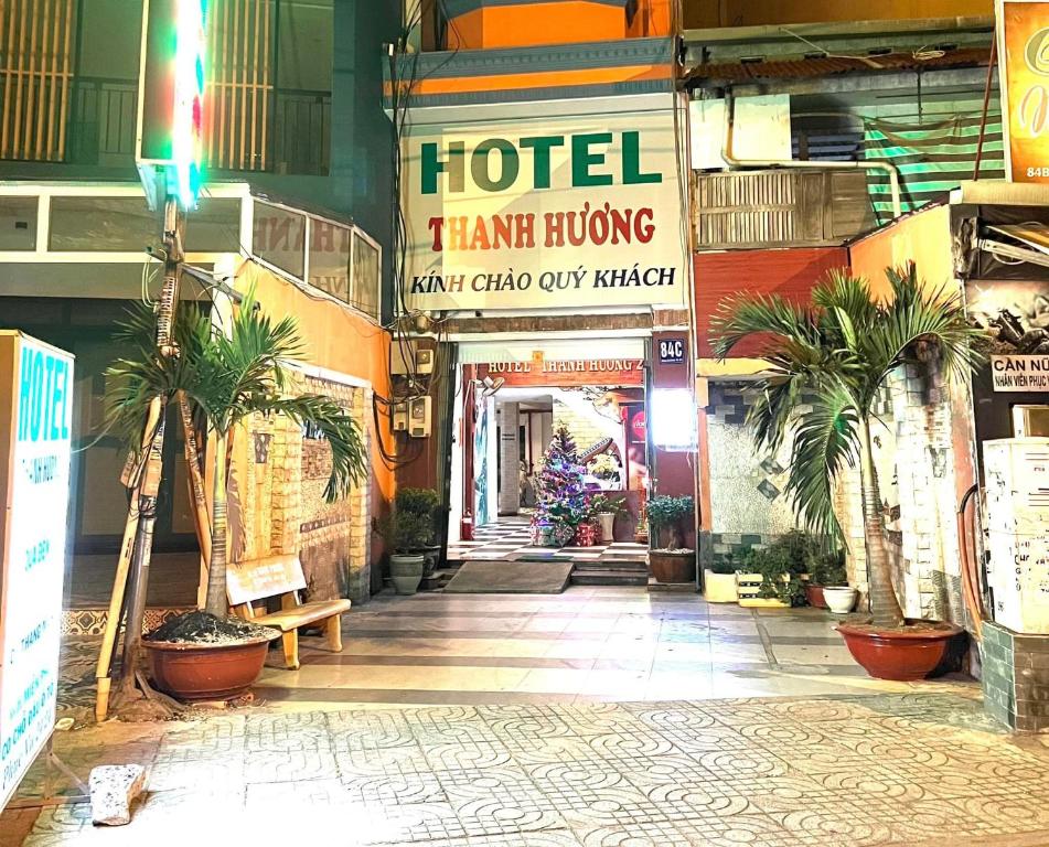 einen Hotelflur mit Palmen in einem Gebäude in der Unterkunft Thanh Hương Hotel in Ho-Chi-Minh-Stadt