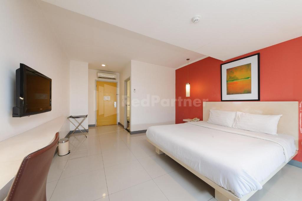 a bedroom with a large bed and a tv at NamRoom Hotel Glodok RedPartner in Jakarta