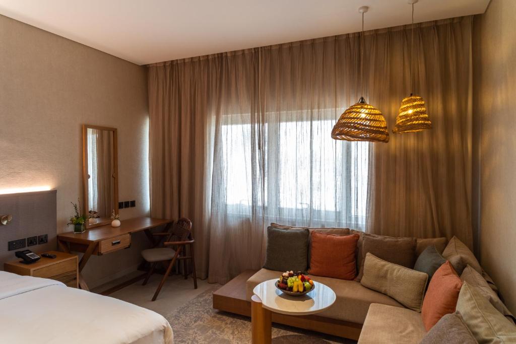 a hotel room with a couch and a bed at ERTH Abu Dhabi Hotel in Abu Dhabi