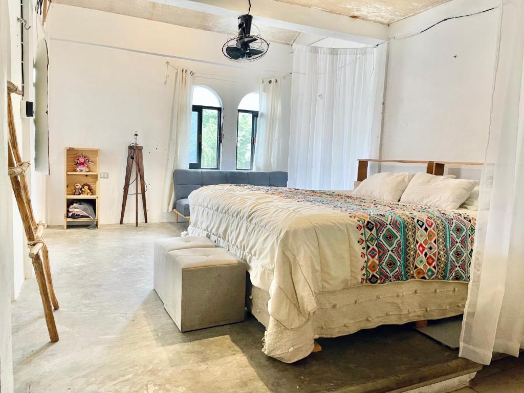 een slaapkamer met een groot bed en een tafel bij Casa Iguana in Isla Mujeres