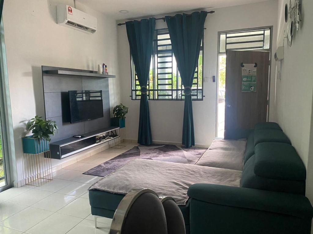 uma sala de estar com um sofá e uma televisão de ecrã plano em Creatills luxury homestay Kulim & hi-tech em Kulim