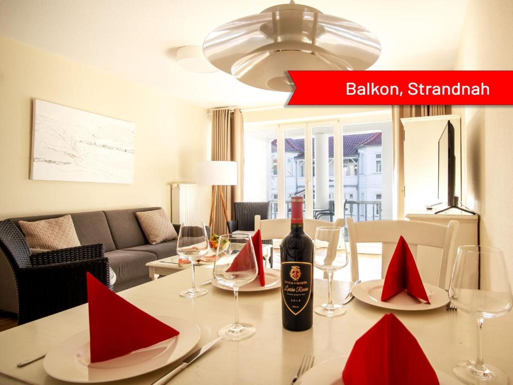 a bottle of wine sitting on a table with red napkins at Villa Strandidyll Neubau Ferienwohnung 1 1 mit Balkon in Binz