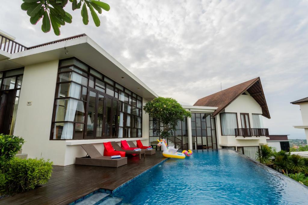 a villa with a swimming pool in front of a house at Jimbaran Sea View Villa in Jimbaran